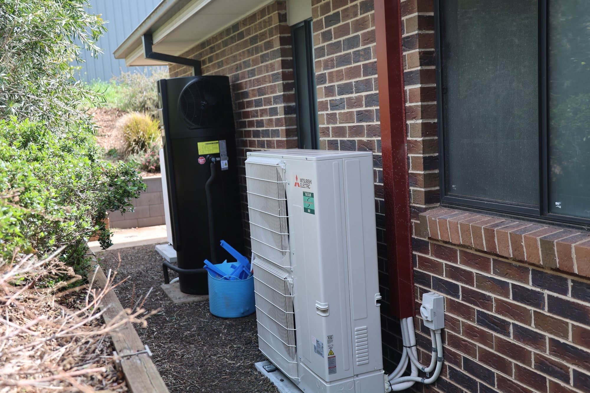 Condenser and hot water unit down the side of the house