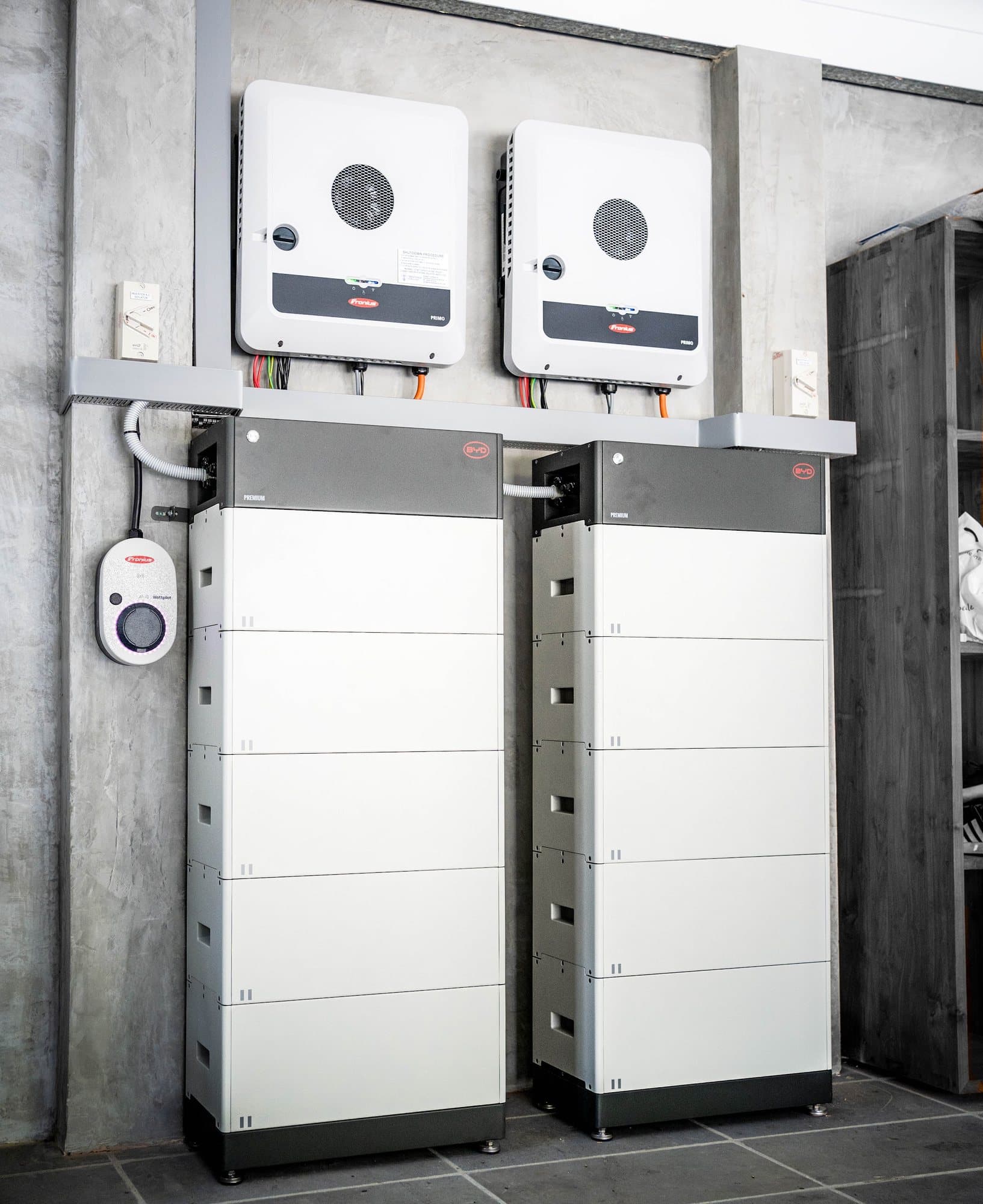 A completed home energy system — twin inverters, battery stacks and an EV charger